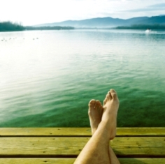 Relaxed feet on dock next to lake